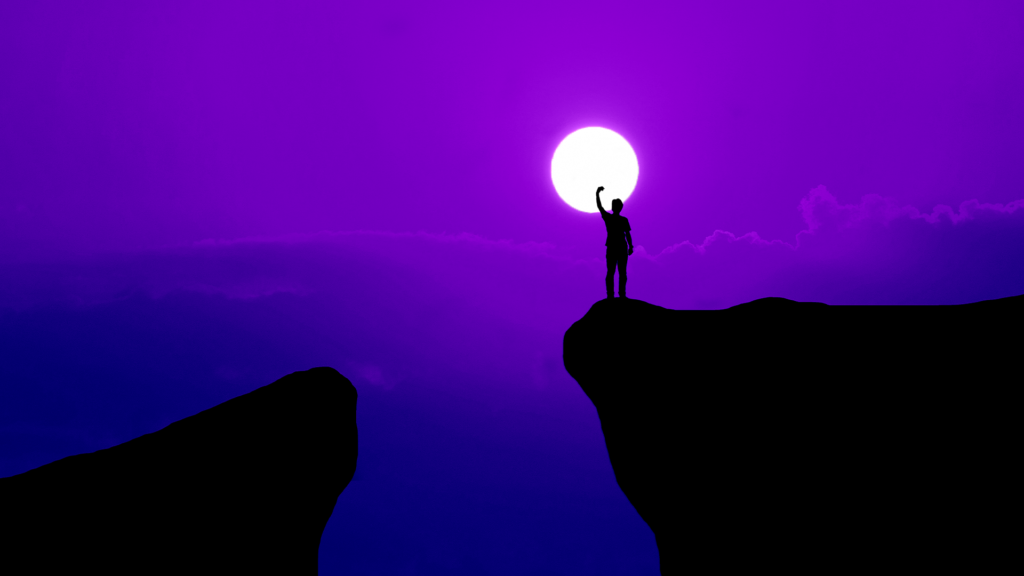 Silhueta de uma pessoa no topo de uma montanha, em contraste com o Sol, demonstrando a importância da Jornada do Herói do empreendedor como um dos serviços de marketing digital.