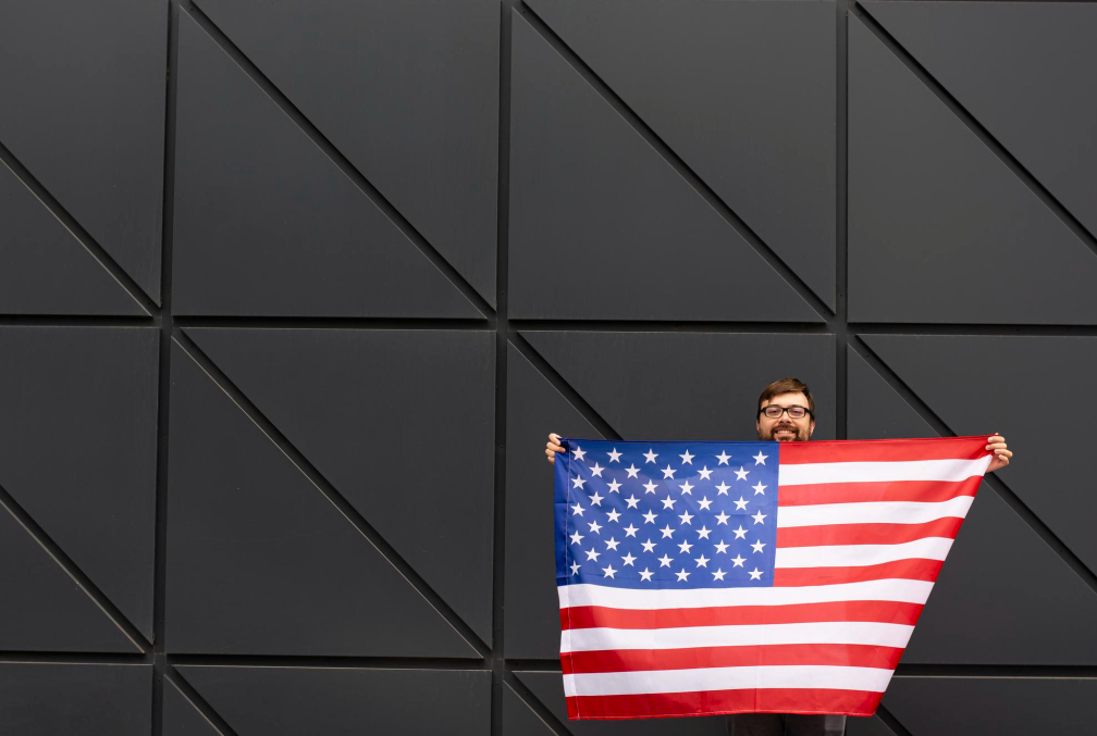 Homem segurando uma bandeira americana após descobrir como abrir empresa nos Estados Unidos