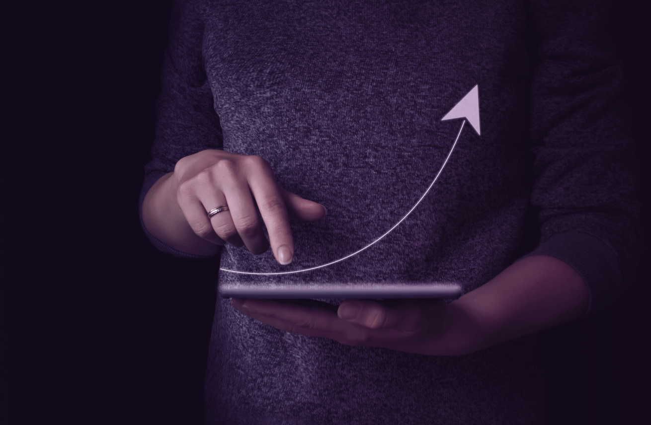 Mão de um homem segurando o tablet com uma seta para cima, representando os retornos do investimento no exterior caso a empresa não cometa os erros citados.