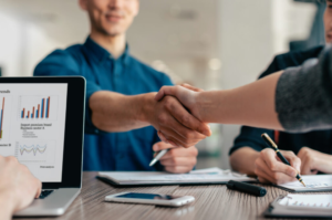 Homens de negócios apertando as mãos em uma reunião de fechamento de contrato de terceirização comercial.