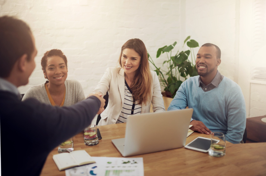 Equipe estratégica comemorando o investimento em terceirização comercial.