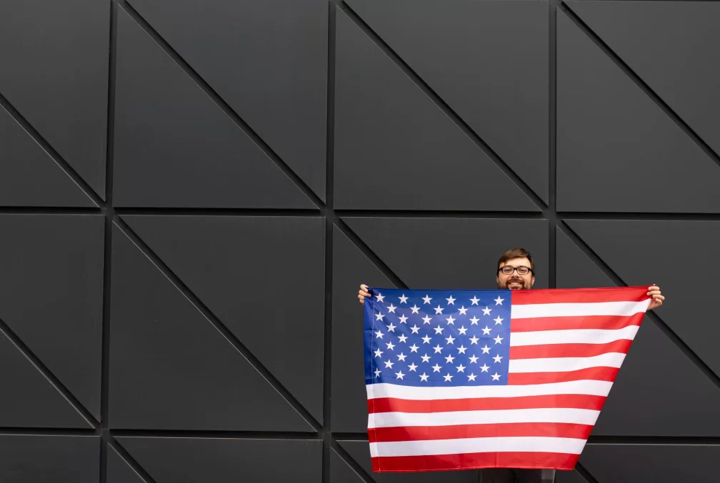 Homem segurando uma bandeira americana após descobrir como abrir empresa nos Estados Unidos