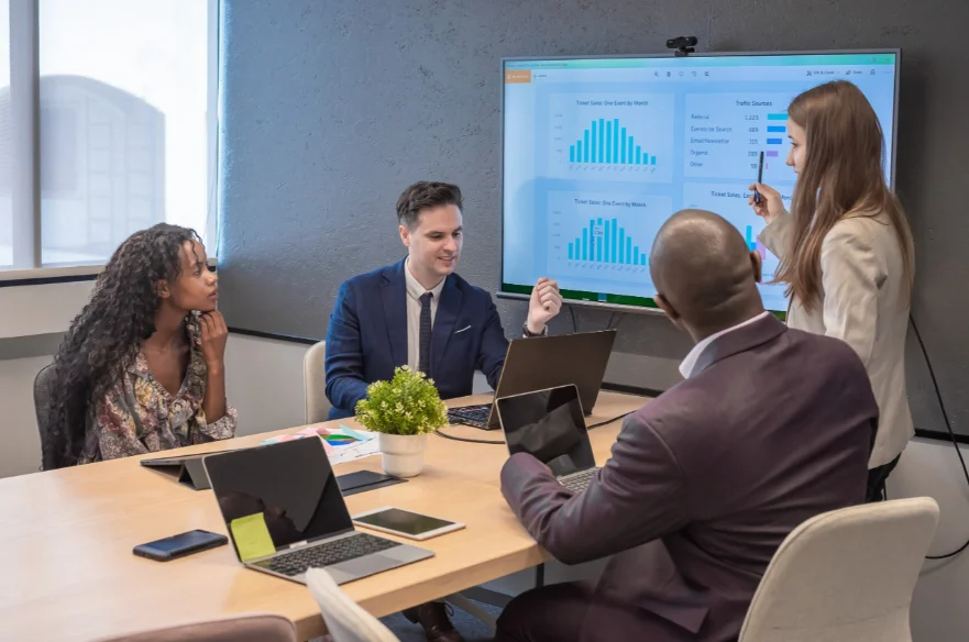 Quatro pessoas em uma sala de reunião discutindo questões das estratégias de growth.